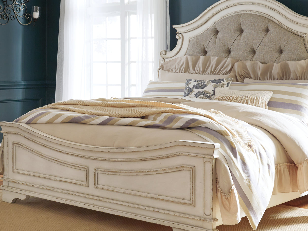 Realyn Chipped White King Panel Upholstered Bed, Dresser, Mirror And Chest